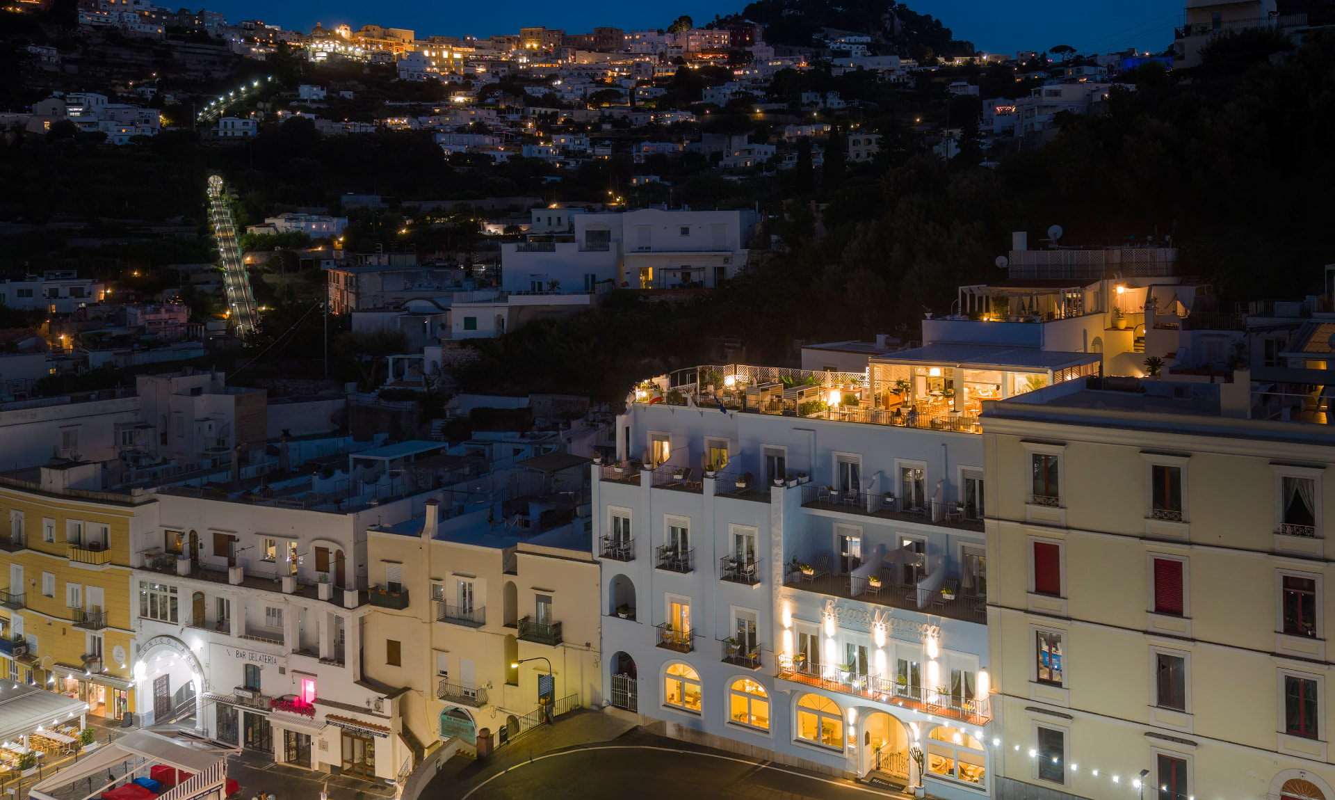 Capri di notte vista dall’alto, con il Relais Maresca illuminato e la funicolare