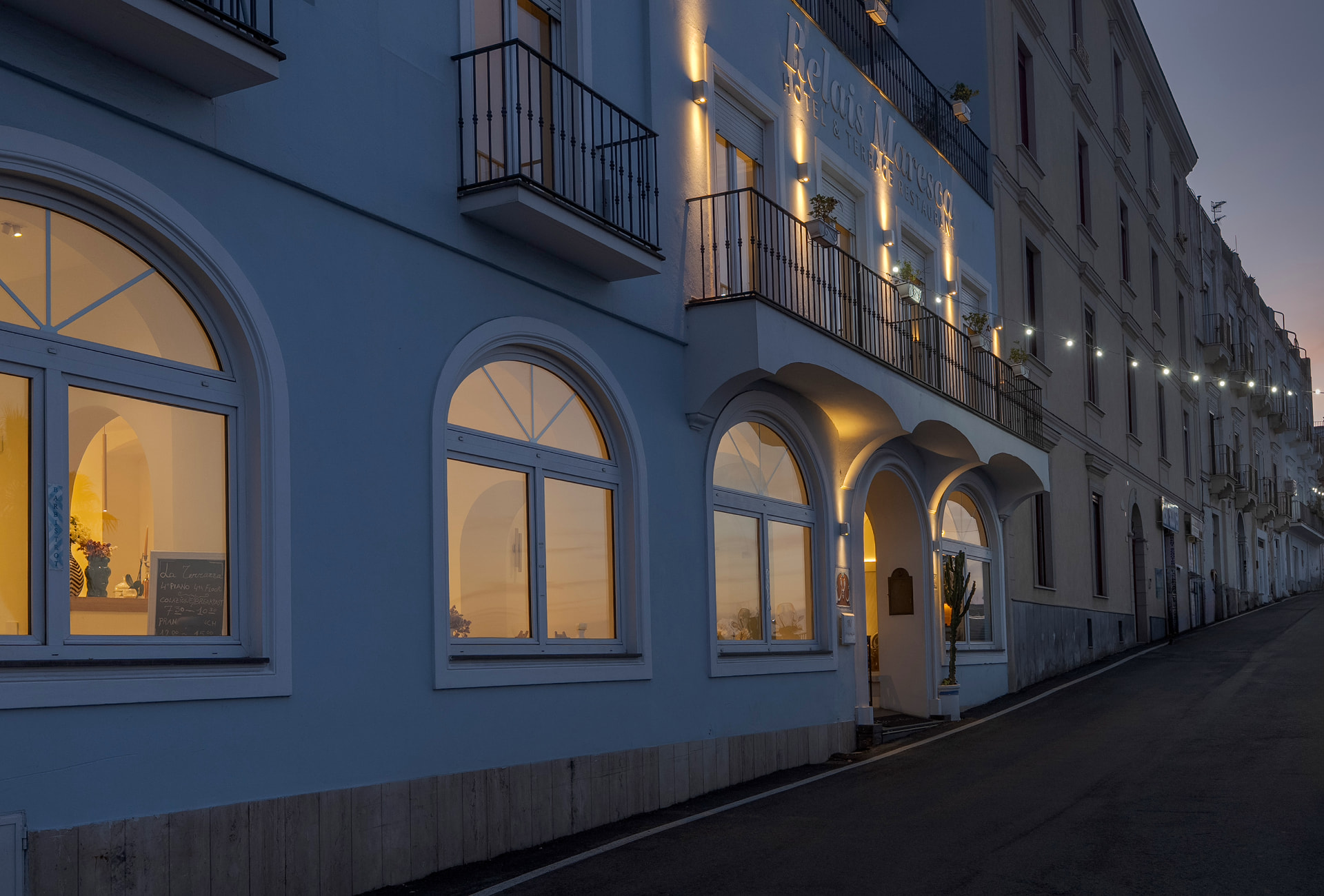 Il Relais Maresca di sera, con la facciata azzurra illuminata