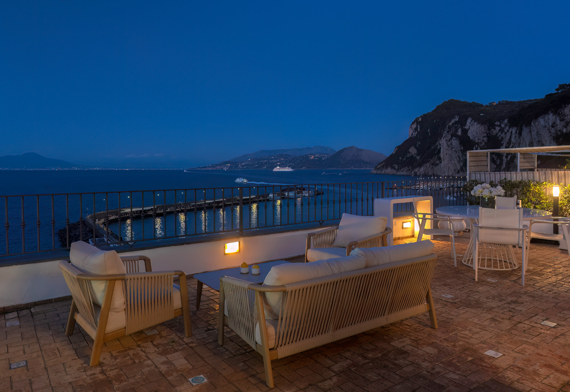 Terrazza di Relais Maresca al crepuscolo, con vista sul porto di Marina Grande e sul golfo di Napoli